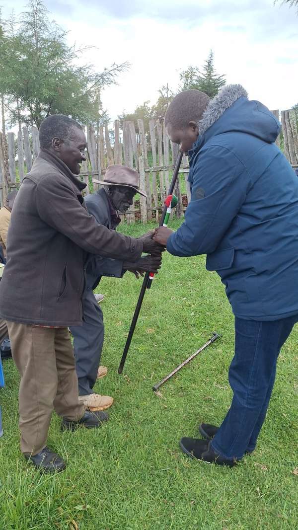 Long’ole bows to greet an elder holding a beaded staff