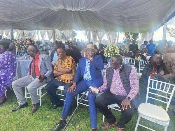Long’ole seated among guests under a decorated tent