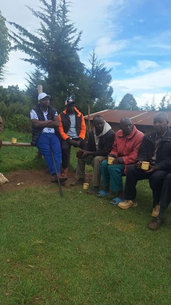 Long’ole on a bench with elders holding mugs of tea