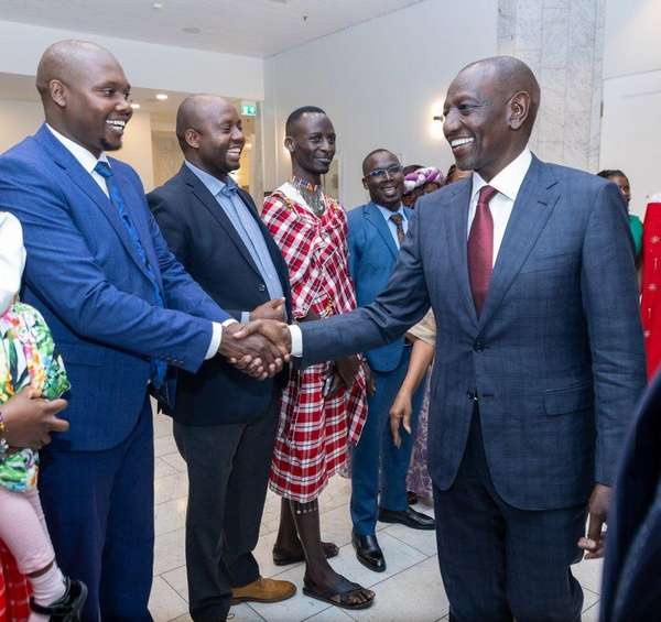 Long’ole shakes hands with President William Ruto at an indoor event